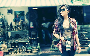 woman holding camera near souvernir store HD wallpaper